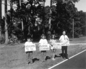 Group holding welcome signs for the Florida Seafood Festival - Apalachicola, Florida