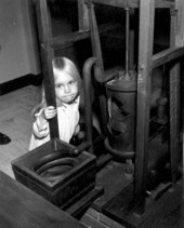 A little girl standing behind the ice machine at the John Gorrie Museum - Apalachicola, Florida.