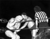 Harley Race trying to get Dusty Rhodes out of the ring corner during their NWA wrestling match - Key West, Florida.