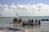 Participants in annual Key West raft race leaving Monroe Beach and headed for the water.