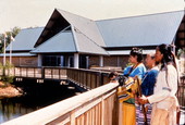 View showing Seminole Indians standing near the Ah-Tah-Thi-Ki Museum of the Seminole Tribe of Florida.