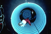 View showing visitor crawling through a rolling barrel at the Mystery Fun House attraction in Orlando, Florida.