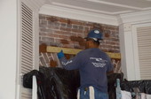 Masonry repair specialist with Structural Preservation Systems, Inc., examining brick door header for repointing and repair at Grove property in Tallahassee, Florida.