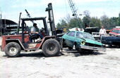 Remains of car being hoisted for crushing machine - Mims, Florida