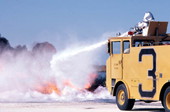 NAS Key West Fire Dept. conducting "Hot Drill" training, turret ops, on old RA-5C acft in the drill pit..