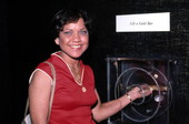 Ann McDonald lifts gold bar from the "Atocha" treasure display at Mallory Square..