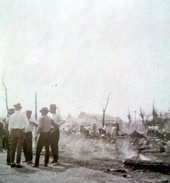 Men huddled together near the remains from the "Great Fire of 1923" - Key West, Florida.