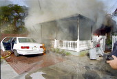 View of house fire on 1709 Flagler Ave. from the front of the structure showing fire extension to vehicle in front..