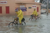 Couple riding bicycles past Pak Mail at 1824 Flagler Avenue during Hurricane Wilma - Key West, Florida.