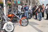 People admiring motorcycles on display during the Boardwalk Chopper and Custom Bike Show - Daytona Beach, Florida.