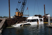 Sunk yacht being hoisted by crane from Garrison Bight Marina - Key West, Florida.
