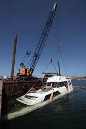 Sunken yacht being retrieved by crane from Garrison Bight Marina - Key West, Florida.