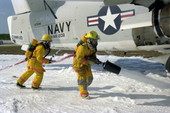 NAS Key West firefighters applying AFFF foam around an old Skywarrior military plane during a training class.