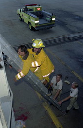 NAS Key West Fire Dept. firefighter Kevin Bravo (right) carrying FF Diego Toiran down an extension ladder during rescue carry training class conducted at Bldg. A-132.
