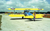 View showing WWI era Stearman bi-planes, painted in the Navy flight trainer aircraft paint scheme, taxiing past spectators during the EAA Fly-In at the Lakeland airport.