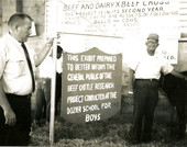 School superintendent Lenox Williams, left, and herdsman B.M. Townsend standing next to an exhibit sign at the Florida School for Boys in Marianna, Florida.