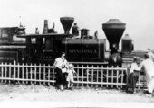 Mother and child standing by Northern Pacific's first engine