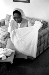 Sister Rouby Balmas displaying hand-made christening gown - Miami, Florida.