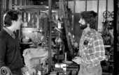 Folklorist Peter Roller listening to apprentice Greek sponge diving helmet maker Nick Toth in his grandfather's machine shop - Tarpon Springs, Florida.