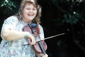 Amy Cox laughing while playing the fiddle- Fort Lauderdale, Florida.