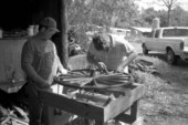 Wheelwright and coach maker John Luther and his apprentice Raymond Richardson working with a wagon wheel- McAlpin, Florida
