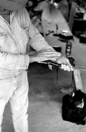 Glen Simmons holding a piece of wood that is part of his Everglades skiff- Florida City, Florida.