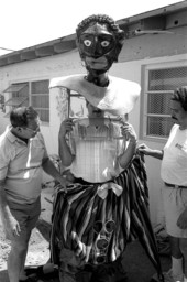 Isaac Duenas (L) and apprentice Ramon Zepeda putting gigante costume onto Isaac's son David - North Miami Beach, Florida.