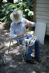 Cow whip maker George "Junior" Mills coiling sections of whip - Okeechobee, Florida.