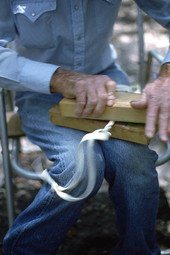 Cow whip maker George "Junior" Mills rolling a whip between blocks of wood - Okeechobee, Florida.