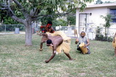 Nigerian acrobatic dancer Felix Omeben performs as Augustine Omeben looks on and Moses Campbell drums - North Miami, Florida.
