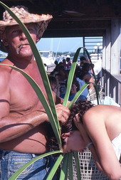 Palm frond hat maker Vic Simmons sizing hat to customer's head - Boynton Beach, Florida.
