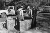 Horace Temples, Ted Temples, Terry Hill, and unknown helper installing kettle in cane furnace at the Stephen Foster State Folk Culture Center - White Springs, Florida.
