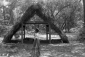 Woman in front of Seminole chickee at the 1985 Florida Folk Festival - White Springs, Florida