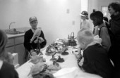 Unidentified man showing wildlife carvings to school group.