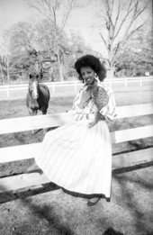 Fashion model sits on fence with a cat - Tallahassee, Florida.