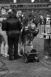 Kelly Lowery # 12, Quarterback, stands by heater on sidelines - Atlanta, Georgia.