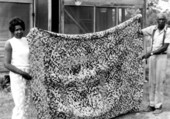 Queenie Udell holding up one of her yo-yo quilts in White Springs, Florida.