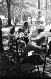 Rufus Adams showing onlookers how to make corn shuck chair bottoms