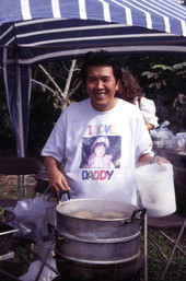 Man with food at the Wat Buddharangsi buddhist temple during festival - Miami, Florida.