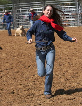 Unidentified woman with a calf branding iron at the Polk Ranch rodeo.