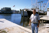 Dan Leonard on a dock in front of shrimp boats - Tarpon Springs, Florida.