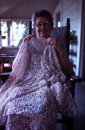 Woman holding up her tatting item