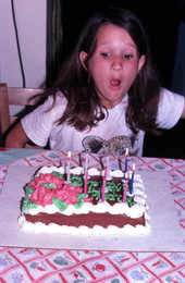 Girl blowing out candles on a birthday cake