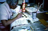 Mrs. Cheek picking from different facial expressions to put on her doll - Miami, Florida.
