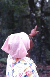 Lucreaty Clark pointing towards white oak trees she will use to make baskets