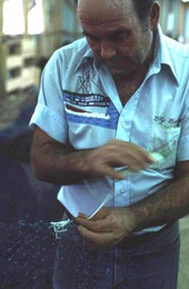 Net maker Billy Burbank II in the middle of repairing a fishing net - Fernandina Beach, Florida