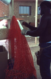 Worker repairing a fishing net - Fernandina Beach, Florida