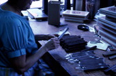 Mrs. Rafael Martinez putting cigars into plastic wrappers in Little Havana - Miami, Florida.