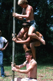 Boys getting onto each other's shoulders for greased pole game - White Springs, Florida