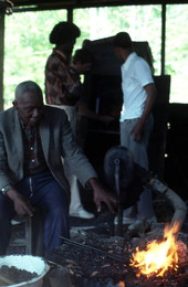 Blacksmith Thomas Rains at work while others look on - Jefferson County, Florida